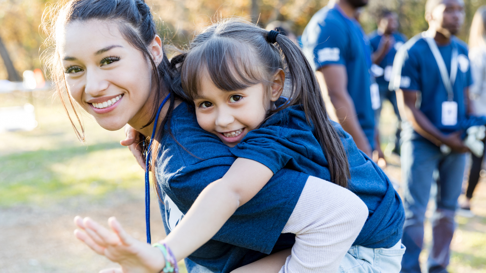 woman giving child a piggy back ride